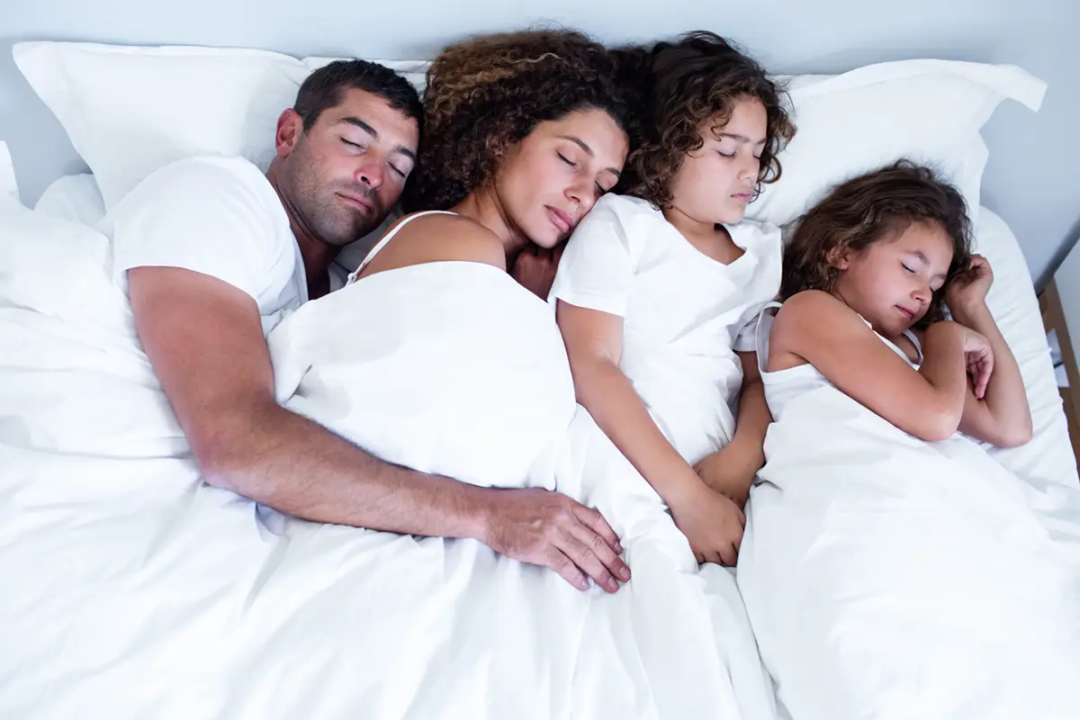 Padres e hijos durmiendo juntos en la misma cama